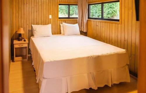 a large white bed in a room with a window at Hotel Brisa do Japi in Cabreúva