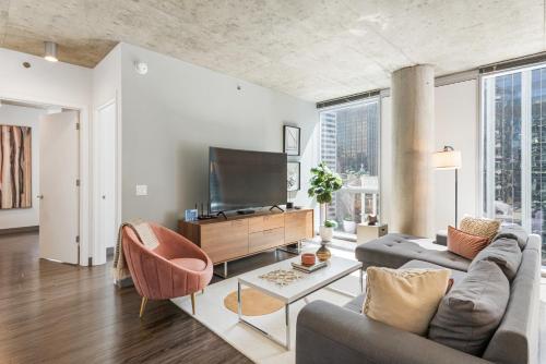 a living room with a couch and a tv at Indoor Pool Gym Rooftop-215-by Cloud9 in Chicago