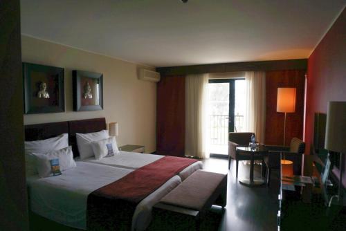 um quarto de hotel com uma cama e uma janela em Apartamento Villa Galé Cascais em Cascais