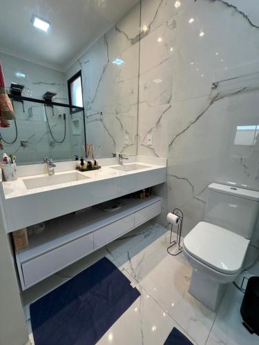 a bathroom with a sink and a toilet and a mirror at Casa para Agrishow in Ribeirão Preto