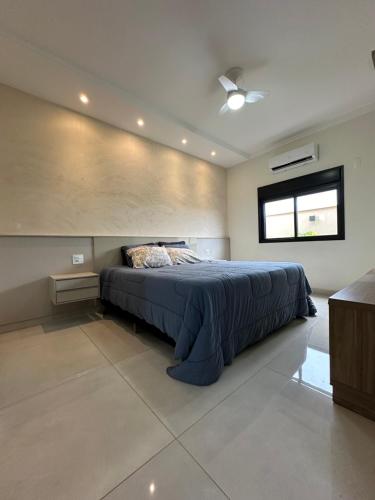 um quarto com uma cama e uma janela em Casa para Agrishow em Ribeirão Preto