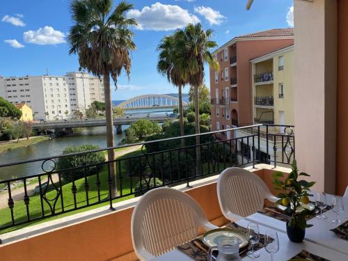 balcón con mesa, sillas y vistas al río en Ste Maxime T3 Terrasse vue mer et avec piscine, en Sainte-Maxime