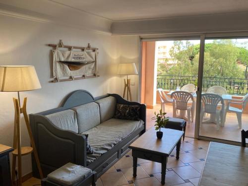 una sala de estar con un sofá y una mesa en Ste Maxime T3 Terrasse vue mer et avec piscine, en Sainte-Maxime