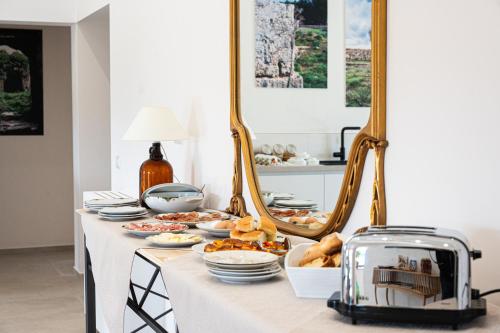 un tavolo con piatti di cibo e uno specchio di AgriBio Villa Ribes ad Altamura