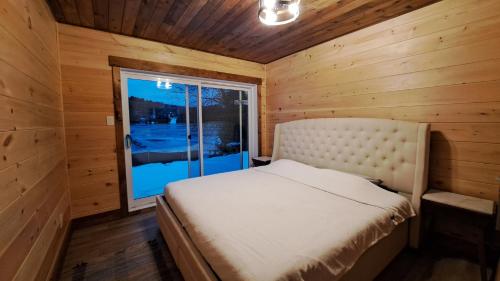 Tranquil Comforts في Val des Monts: غرفة نوم بسرير في غرفة خشبية