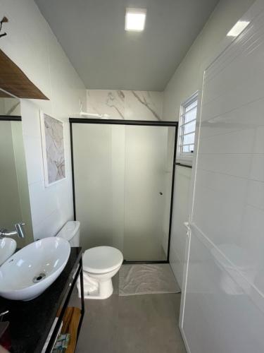Un baño con inodoro, lavabo y ducha. en Casa Floratta, en Santa Cruz do Sul