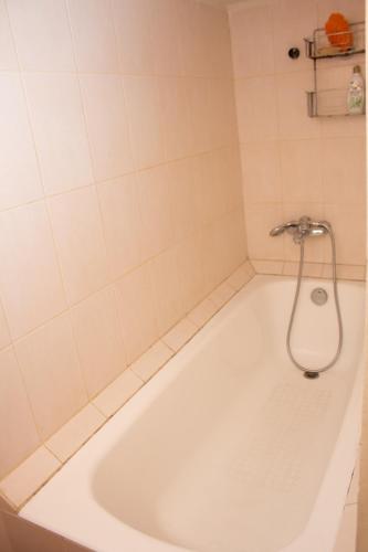 a bath tub with a shower in a bathroom at Deribasovskaya Shanti electricity all time in Odesa