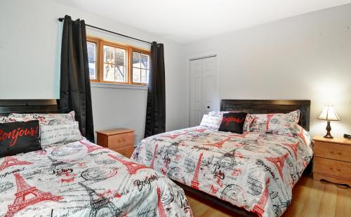 - une chambre avec 2 lits et une fenêtre dans l'établissement Chalets Alpins- 39 Chemin des Skieurs, à Stoneham