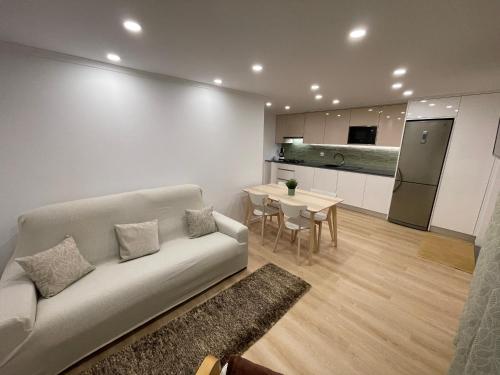 a living room with a couch and a table and a kitchen at Neto Pinto - Casa de férias / fins de semana. in Lourinhã