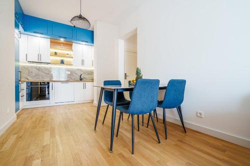 cocina con mesa de comedor y sillas azules en Skyline Apartments by In Property en Bečići