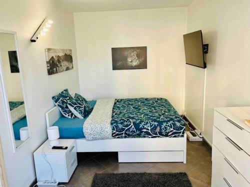 une chambre avec un lit avec des draps bleus et un miroir dans l'établissement FELINE’S Appart - T2 Moderne 51 m2, proche centre, à Poitiers