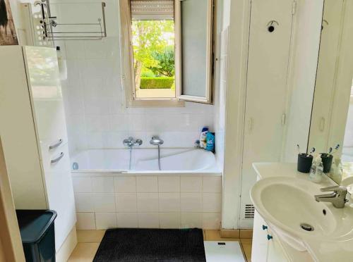 une salle de bain blanche avec une baignoire et un lavabo dans l'établissement FELINE’S Appart - T2 Moderne 51 m2, proche centre, à Poitiers
