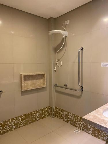 a bathroom with a shower and a sink at Premium Hotel in Mombaça