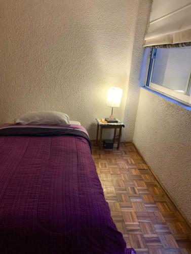 a bedroom with a bed and a table with a lamp at Bonita y Céntrica habitación con sofa cama in Mexico City