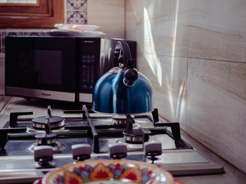 a blue tea kettle on top of a stove with a microwave at BACANA CABAÑAS DE ALQUILER in Mazamitla