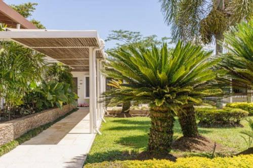 a palm tree in a yard next to a house at Balmoral House With Pool & Jacuzzi in La Pintada