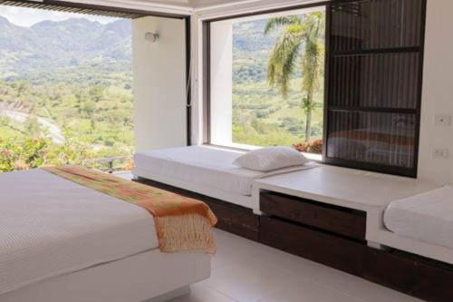 a bedroom with two beds and a large window at Balmoral House With Pool & Jacuzzi in La Pintada