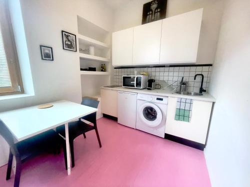 une cuisine avec une machine à laver et une table dans l'établissement Ruby- Quai St Laurent- Bastille, à Grenoble