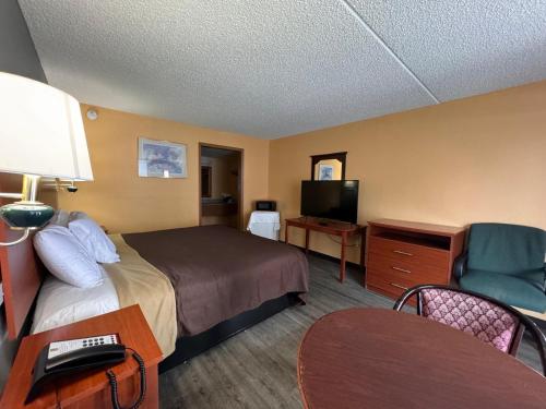 pokój hotelowy z łóżkiem i telewizorem w obiekcie College Inn Spartanburg w mieście Spartanburg