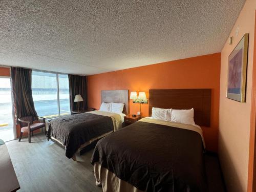 a hotel room with two beds and a window at College Inn Spartanburg in Spartanburg
