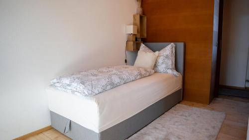 Una cama pequeña con sábanas blancas y almohadas. en Eva Apartments - Nordkette, en Innsbruck
