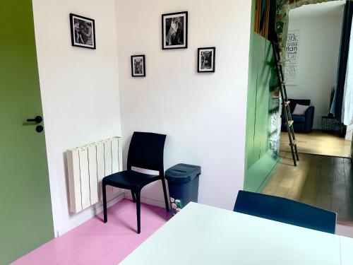 une chaise assise dans une pièce dotée d'un mur blanc dans l'établissement Ruby- Quai St Laurent- Bastille, à Grenoble