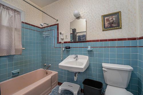 a bathroom with a sink and a toilet and a bath tub at Jensen's RV Park and Motel in South Haven