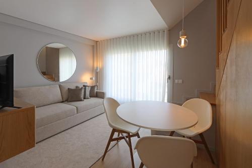 een woonkamer met een witte tafel en stoelen bij FLH Boavista Woody Duplexes in Porto