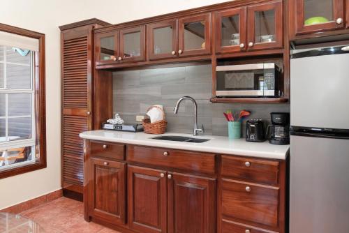 a kitchen with wooden cabinets and a sink and a refrigerator at X'tan Ha- The Waterfront in San Pedro