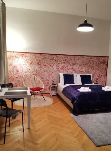 ein Schlafzimmer mit einem Bett und einem Tisch darin in der Unterkunft Lilia in Wien