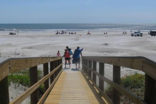 a group of people walking down a boardwalk to the beach at Beach Side complex B23 1 Bed 1 Bath w/Heated Pool in Saint Augustine