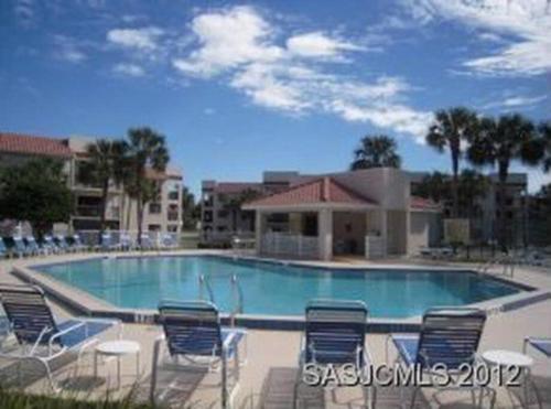 a large swimming pool with chairs at Beach Side complex B23 1 Bed 1 Bath w/Heated Pool in Saint Augustine