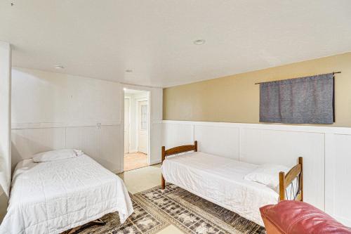 a bedroom with two beds and a couch and a window at Secluded Bigfork Cabin with Yard and Fire Pit! in Bigfork