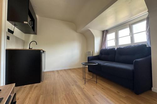 un salon avec un canapé bleu et une table dans l'établissement Comfortable 16 m love nest in Caen, à Caen