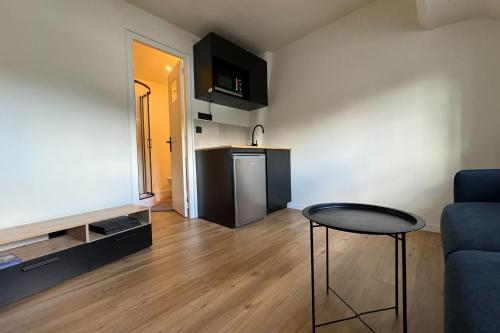 un salon avec un canapé bleu et une table dans l'établissement Comfortable 16 m love nest in Caen, à Caen
