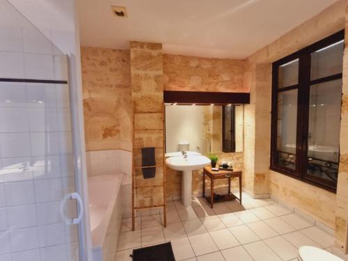 a bathroom with a sink and a bath tub and a sink at Château Julie in Virsac