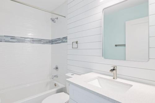La salle de bains blanche est pourvue d'un lavabo et d'un miroir. dans l'établissement Superb Bonita Springs Residence Near Downtown, à Bonita Springs