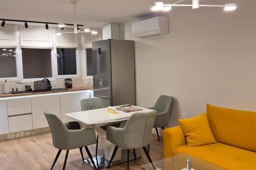a living room with a table and chairs and a kitchen at Panorama Apartment in Plovdiv