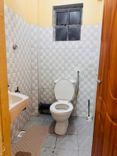 a bathroom with a toilet and a sink and a window at Haven homes in Kiambu