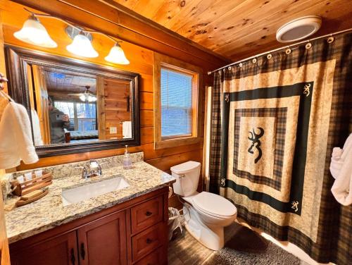 a bathroom with a toilet and a sink and a mirror at Stairway to Heaven - 3 Master Suite, Location, Privacy, Firepit in Gatlinburg