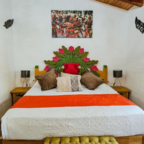 a bedroom with a large bed with a painting on the wall at BACANA CABAÑAS DE ALQUILER in Mazamitla