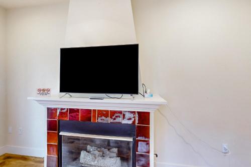 a flat screen tv sitting on top of a fireplace at The Last House On The Left in Redmond