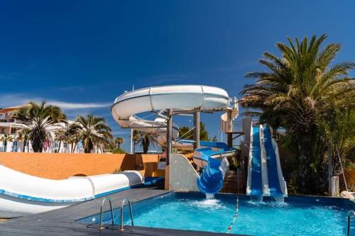 a pool with a water slide in a resort at Mobil-home Le cocon in Canet-en-Roussillon