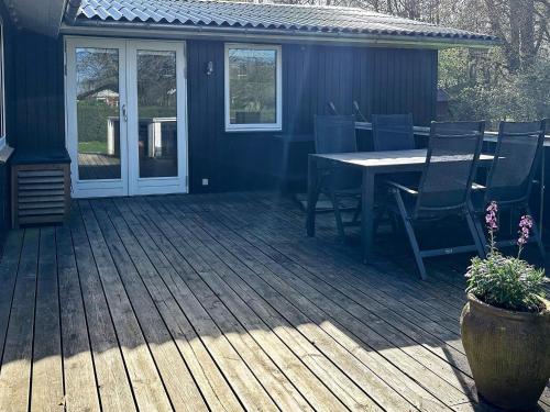 una terraza de madera con mesa y sillas. en 8 person holiday home in Hemmet, en Falen