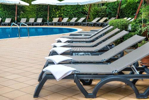 a row of lounge chairs next to a swimming pool at Hotel La Giocca in Rome