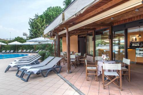 a patio with tables and chairs next to a pool at Hotel La Giocca in Rome