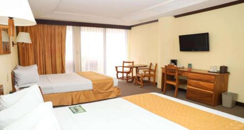 a hotel room with two beds and a desk at Best Western Hotel & Casino Kamuk in Manuel Antonio