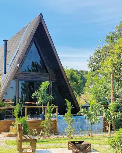 uma casa com um telhado triangular com janelas em Refúgio prox Ctba Chalé Suíço 50m2, 400 m2 de área em Mandirituba