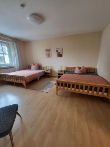 two beds in a room with wooden floors at Geräumige Wohnungen Zentrumsnah Schwandorf in Schwandorf in Bayern