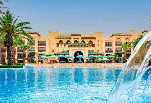 una piscina frente a un complejo con una fuente en Mazagan Beach & Golf Resort, en El Jadida